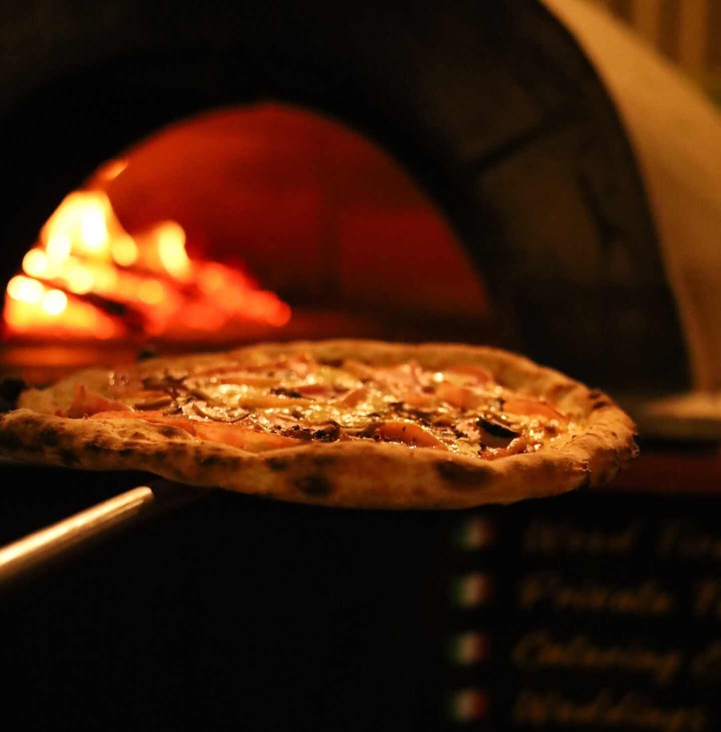 Pizza coming out of the oven